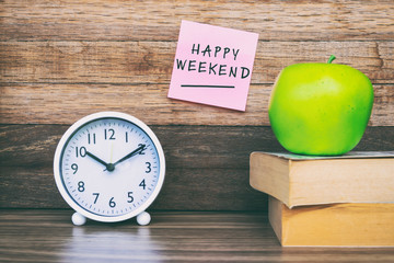 Happy Weekend greeting on sticky notes, office desk.