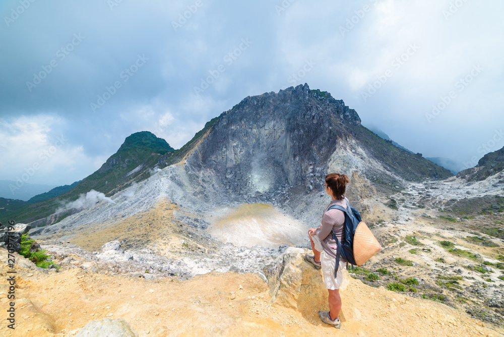 Wall mural Sibayak volcano, active caldera steaming, famous travel destination natural landmark and tourist attraction in Berastagi Sumatra Indonesia. Tourist looking at view from the top, traveling people. - Wall murals