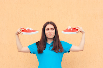 Unhappy Woman Holding a Pair of Red Sport Shoes