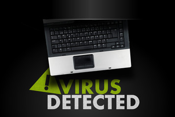 Laptop and words VIRUS DETECTED with warning sign