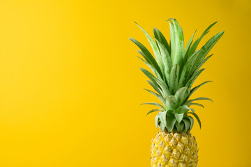Summer concept with pineapple over yellow background