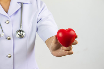 Young woman doctor holding a red heart