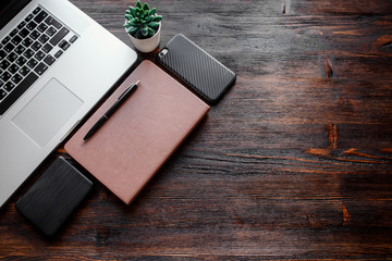 work space of a businessman. view from above . coffee black note and laptop on the desktop with black note. laptop on wooden background