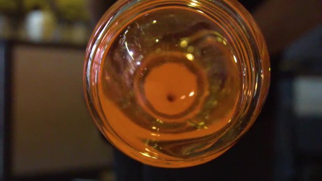 Glassblower in his workshop taking out rod with liquid glass and turning it. Close-up.