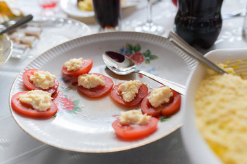 Fototapeta na wymiar Cheese Tomatoes. Home table, the demand for tomatoes. Stuffed tomatoes with cheese and basil