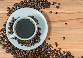 Cup of coffee and coffee beans on wooden background, Vintage tone