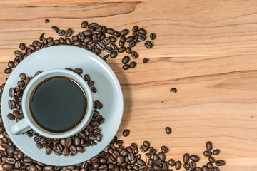Cup of coffee and coffee beans on wooden background, Vintage tone