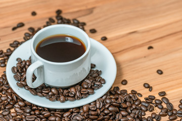 Cup of coffee and coffee beans on wooden background, Vintage tone