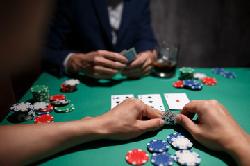 professional poker game. Green poker table with two games. poker player makes a bet by throwing chips on the table