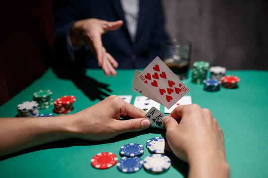 professional poker game. Green poker table with two games. poker player folds by throwing cards on the table