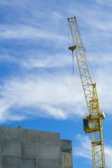 Yellow tower crane. Construction site Unfinished building.