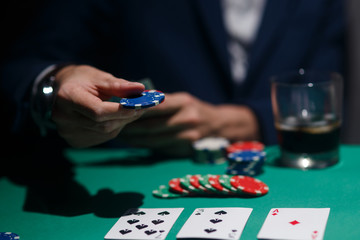 professional poker game. Green poker table with two games. poker player makes a bet by throwing chips on the table