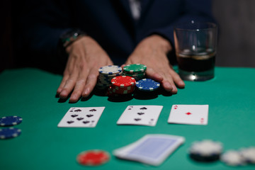 Fototapeta na wymiar poker player bets all chips. Big poker risks. poker table and hands close-up