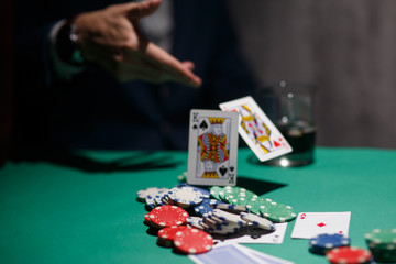 professional poker game. Green poker table with two games. poker player folds by throwing cards on...
