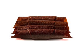 Fruit leather rolls in row isolated on white background