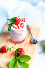 Summer dessert, strawberries ice ceam decorated with mint leaves. On a blue table, copy space, slective focus.