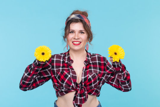 Summer, pin-up and fun concept - pretty woman with gerberas over the blue background