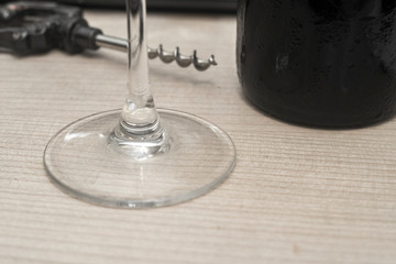 vintage wine opener, glass and wine bottle on a wooden background
