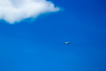 Fototapeta na wymiar Small business jet gains altitude with blue sky on the background