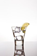 glass of water with lemon and ice cubes on isolated background