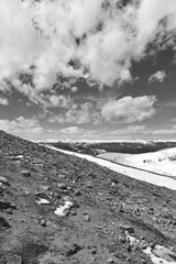 Black and white photography of beautiful high altitude blue alpine lake with snow capped peaks, Rocky Mountains, Colorado