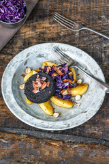 Warm salad of red cabbage, black pudding and apple with crispy bacon and crushed hazelnuts - overhead view