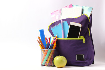 school backpack with school stationery on a light background. Concept back to school. Place for text