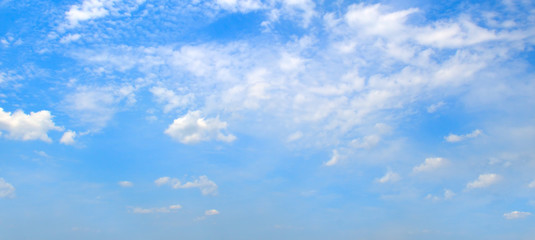 Naklejka na ściany i meble Fluffy clouds in the blue sky. Wide photo.