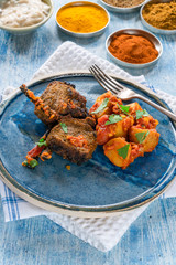 Spiced lamb cutlets with Bombay aloo with minted yogurt - high angle view