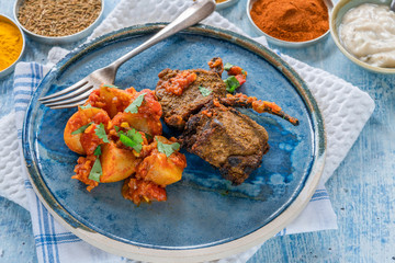 Spiced lamb cutlets with Bombay aloo with minted yogurt - high angle view