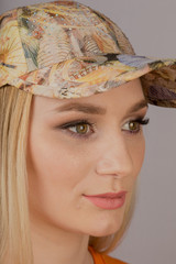 Beautiful girl with natural make-up in a headdress on a gray background.