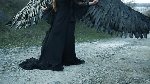 grim picture, unhappy girl with big black wings and heavy horns alone on head in long flying vintage dark dress with lace sleeves loose, lady enchanted and turned into statue by cruel sorceress