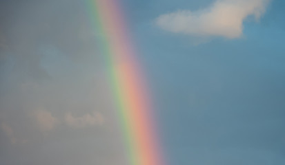 colorful rainbow in sunset cloudy sky