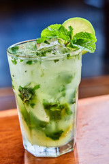 Summer fresh classic mojito with mint and lime garnish on bar top in restaurant 