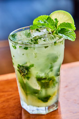 Summer fresh classic mojito with mint and lime garnish on bar top in restaurant 