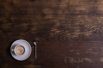 Top view of white espresso coffee cup with espresso coffee and foamy milk on white saucer