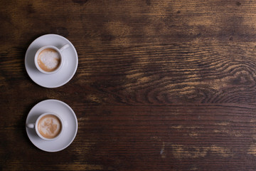 Top view of white espresso coffee cup with espresso coffee and foamy milk on white saucer