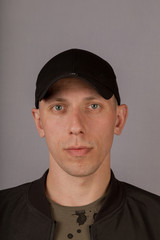 Handsome young man in a headdress on a gray background.