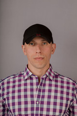Handsome young man in a headdress on a gray background.