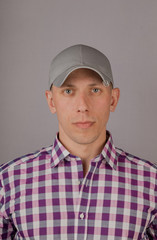 Handsome young man in a headdress on a gray background.