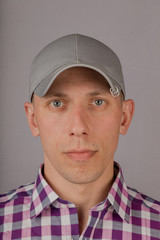 Handsome young man in a headdress on a gray background.