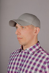 Handsome young man in a headdress on a gray background.