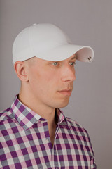 Handsome young man in a headdress on a gray background.