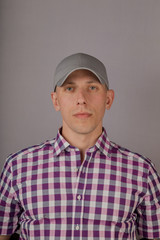 Handsome young man in a headdress on a gray background.