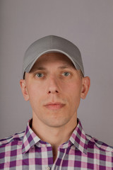 Handsome young man in a headdress on a gray background.