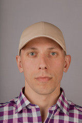 Handsome young man in a headdress on a gray background.