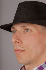 Handsome young man in a headdress on a gray background.