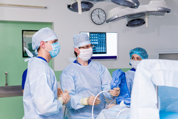 Arthroscope surgery. Orthopedic surgeons in teamwork in the operating room with modern arthroscopic tools. Knee surgery.