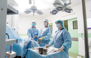 Arthroscope surgery. Orthopedic surgeons in teamwork in the operating room with modern arthroscopic...