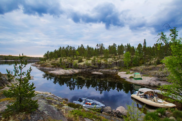 Fototapeta premium Karelia. Russia. Campground on the shore of lake Ladoga. Inflatable motor boats on Ladoga. Camping on lake Ladoga. Rest in tents in Karelia. Outdoor recreation. Karelian nature. Ecotourism in Russia.